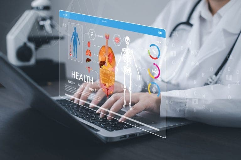 Doctor working on a laptop with a medical technology interface