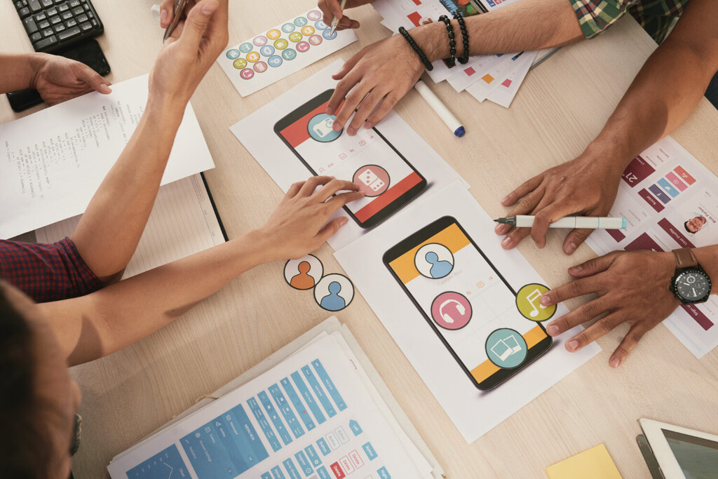 Creative team analyzing social media analytics on multiple devices with colorful brand strategy charts and algorithm performance graphs displayed on screens ALT Text: Marketing team reviewing social media algorithm performance data to fix engagement issues for brand growth